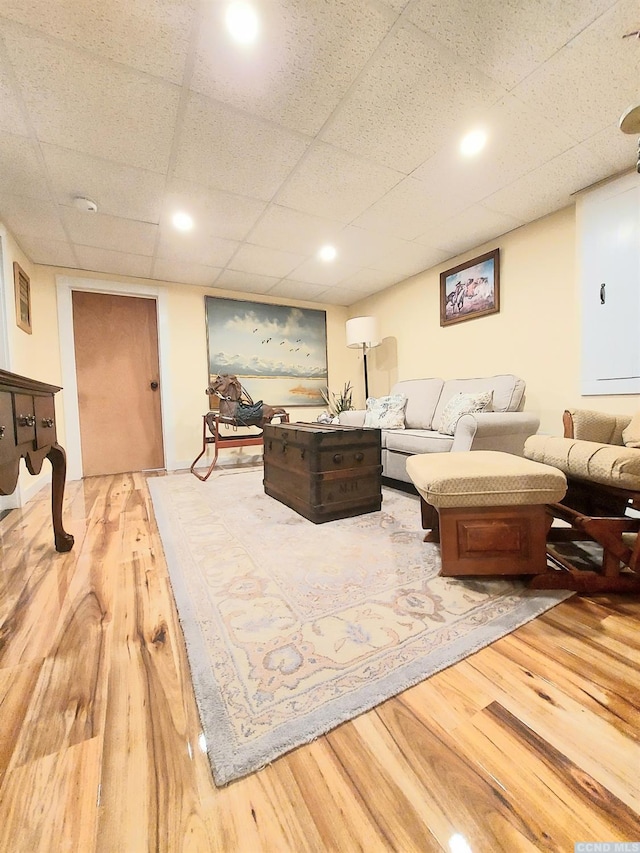 living area with wood finished floors and a paneled ceiling