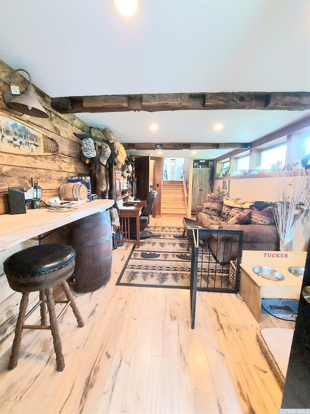 interior space featuring wooden walls, beamed ceiling, stairway, and wood finished floors