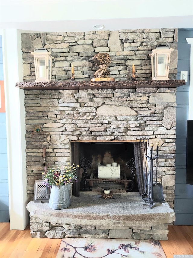 details with a fireplace with raised hearth and wood finished floors