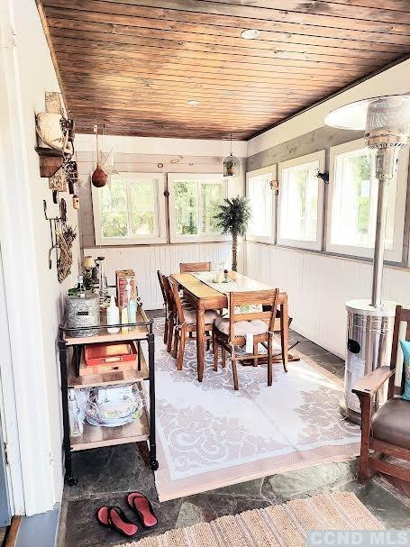 sunroom / solarium featuring a wealth of natural light and wood ceiling