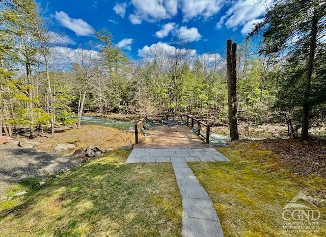 surrounding community with a yard and a wooded view