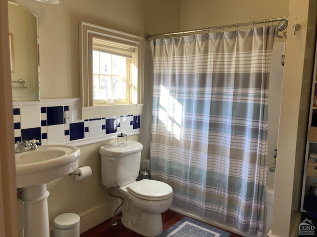 bathroom with decorative backsplash, shower / tub combo, and toilet