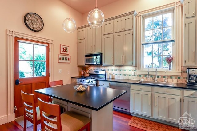 kitchen with plenty of natural light, sink, stainless steel appliances, and decorative light fixtures