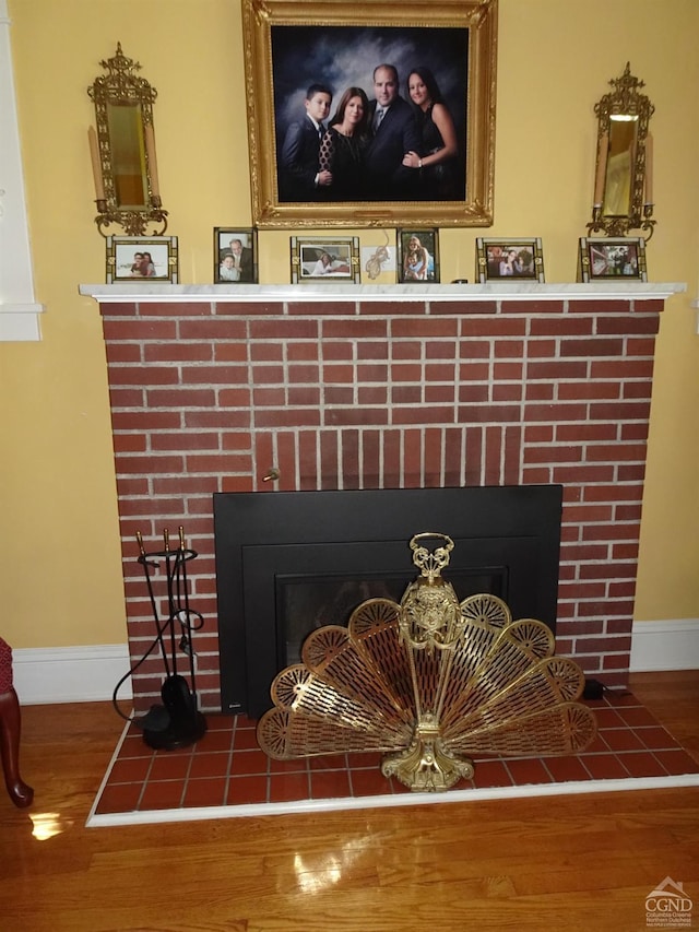 details featuring hardwood / wood-style flooring and a brick fireplace