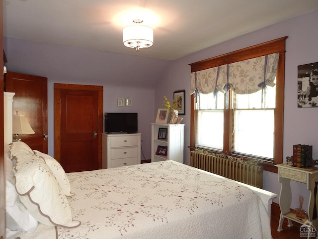 bedroom with lofted ceiling and radiator