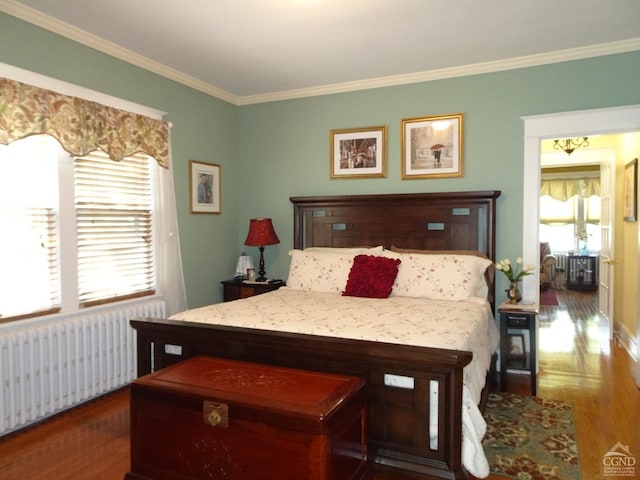 bedroom featuring dark hardwood / wood-style flooring, ornamental molding, and radiator