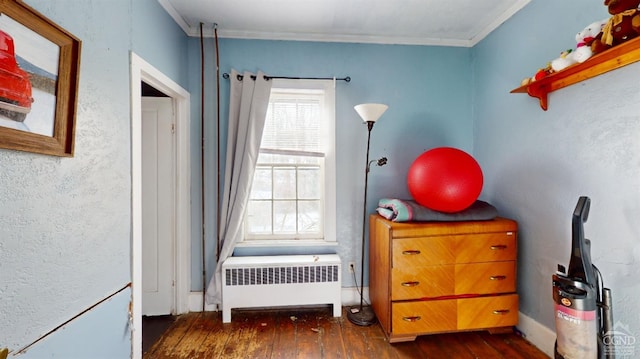 bedroom with ornamental molding, dark hardwood / wood-style floors, and radiator