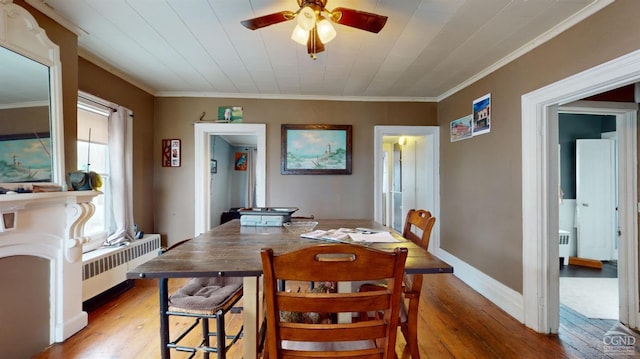 dining area with wood-type flooring, radiator, and crown molding