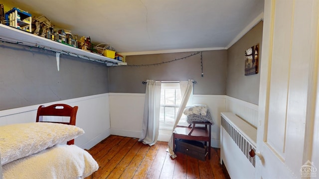 bedroom featuring crown molding, radiator heating unit, and hardwood / wood-style floors