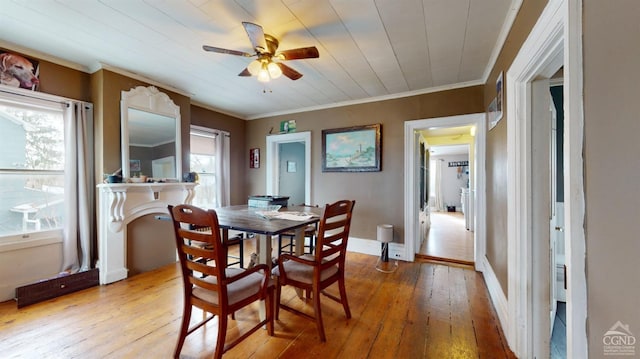 dining room with crown molding, plenty of natural light, and light hardwood / wood-style flooring