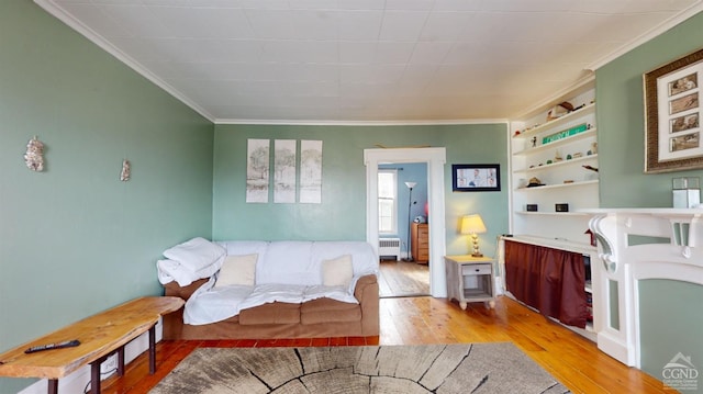 living room featuring ornamental molding, radiator heating unit, and light hardwood / wood-style floors