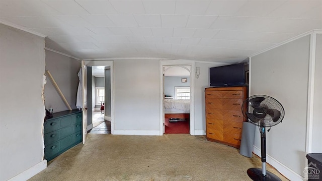 unfurnished bedroom featuring multiple windows, vaulted ceiling, and carpet floors