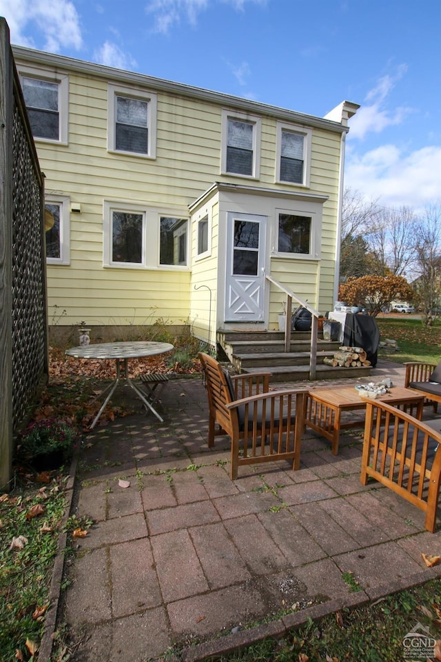 rear view of house with outdoor lounge area and a patio