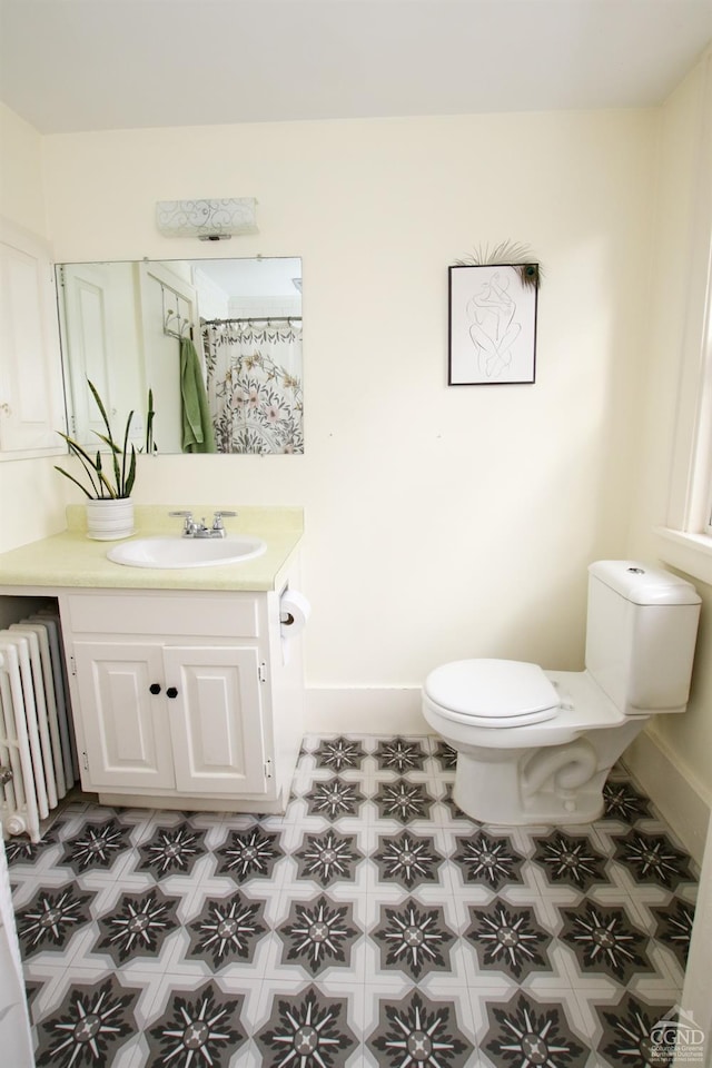 bathroom featuring radiator heating unit, vanity, and toilet