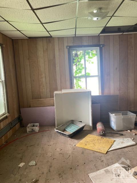 miscellaneous room featuring wood walls, a drop ceiling, and hardwood / wood-style floors