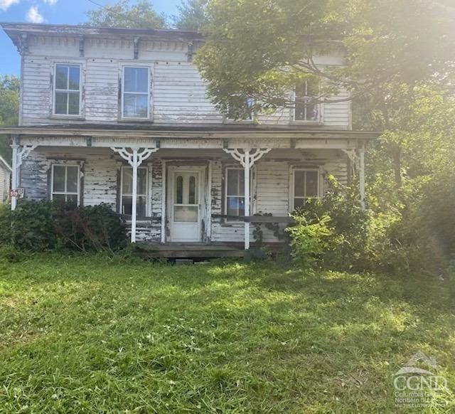 italianate house featuring covered porch and a front lawn