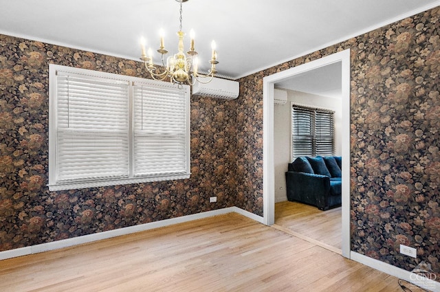 unfurnished dining area with a wall mounted air conditioner, baseboards, wood finished floors, an AC wall unit, and a notable chandelier