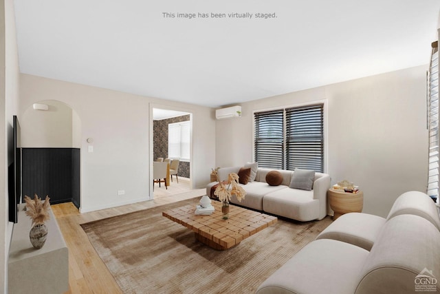 living room featuring light wood-type flooring and a wall mounted AC