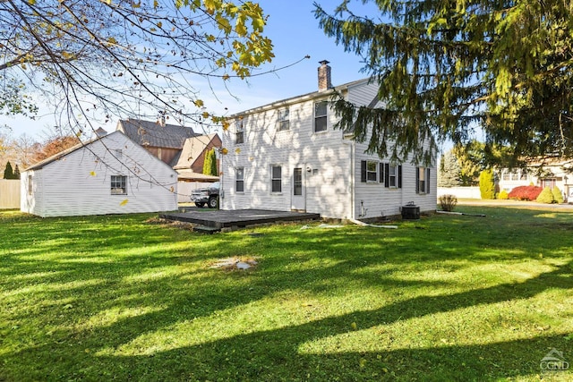 rear view of house with a yard and a wooden deck