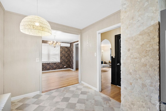 corridor with crown molding and a notable chandelier