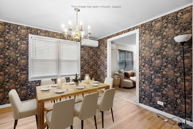 dining area with an AC wall unit, crown molding, a chandelier, and light wood-type flooring