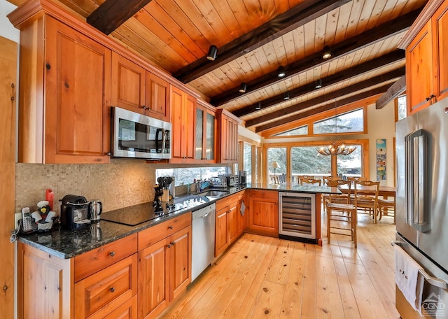 kitchen with wooden ceiling, dark stone counters, appliances with stainless steel finishes, a notable chandelier, and beverage cooler