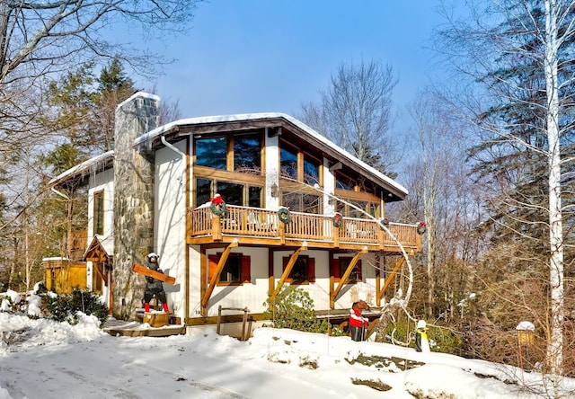 snow covered house featuring a deck