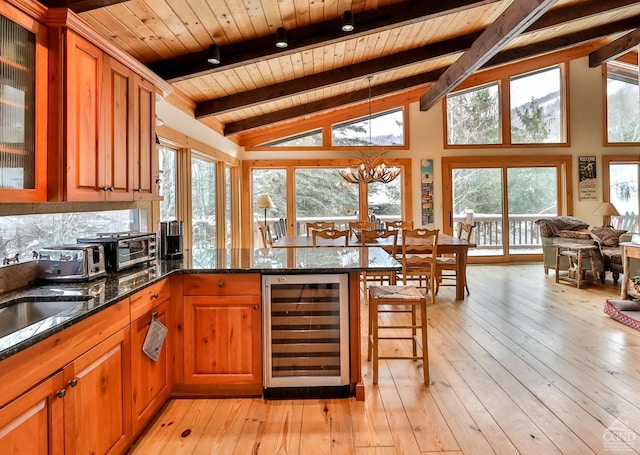 kitchen featuring light wood-type flooring, wine cooler, dark stone countertops, and wood ceiling