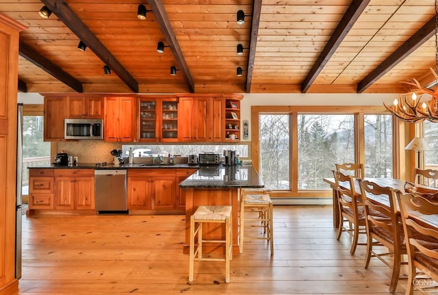 kitchen featuring beam ceiling, wooden ceiling, light hardwood / wood-style floors, and appliances with stainless steel finishes