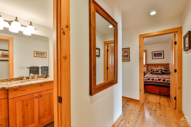 corridor featuring light hardwood / wood-style flooring and sink