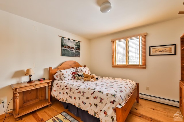 bedroom with light wood-type flooring and baseboard heating