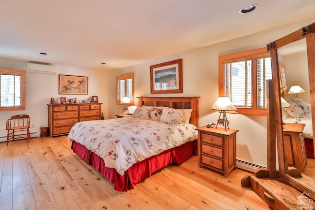 bedroom with a wall mounted AC, light hardwood / wood-style flooring, and a baseboard radiator