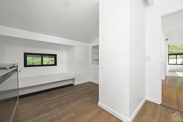 additional living space with dark hardwood / wood-style floors and vaulted ceiling