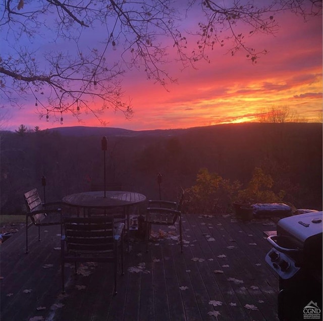 patio terrace at dusk featuring a wooden deck