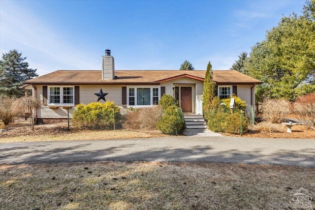 ranch-style house featuring a chimney