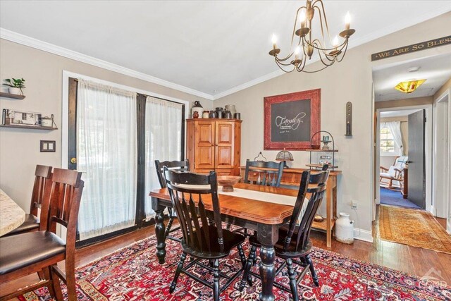 dining area featuring crown molding, baseboards, vaulted ceiling, wood finished floors, and a notable chandelier