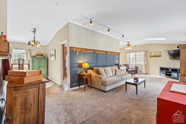 carpeted living room featuring baseboard heating, plenty of natural light, crown molding, and vaulted ceiling