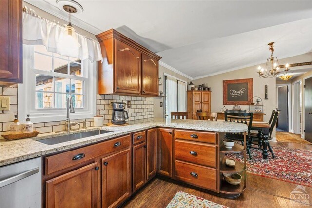 kitchen featuring a peninsula, ornamental molding, a sink, vaulted ceiling, and stainless steel dishwasher