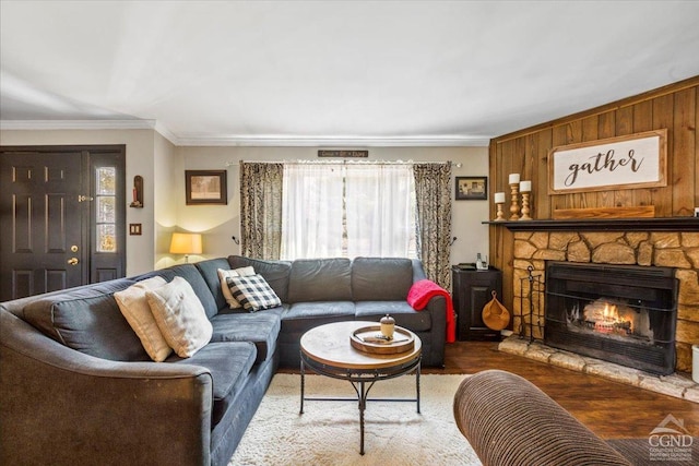 living area with wood finished floors, a fireplace, and ornamental molding