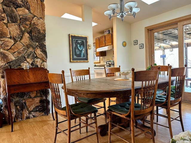 dining area with light wood-style flooring and a chandelier