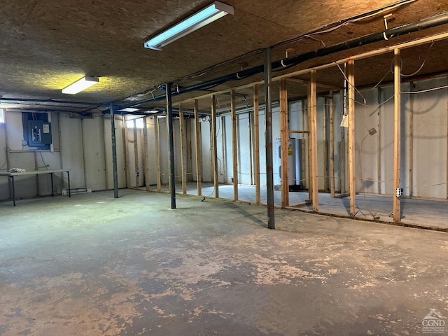 unfinished basement featuring water heater and electric panel