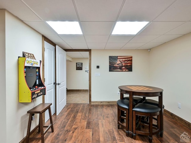 dining area featuring a drop ceiling and dark wood-type flooring