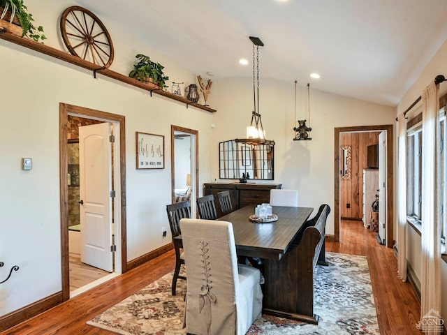 dining area with wood-type flooring and lofted ceiling