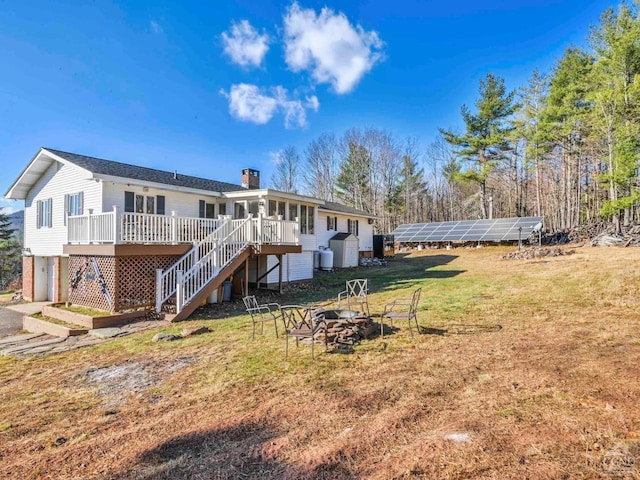 back of house featuring a fire pit and a deck