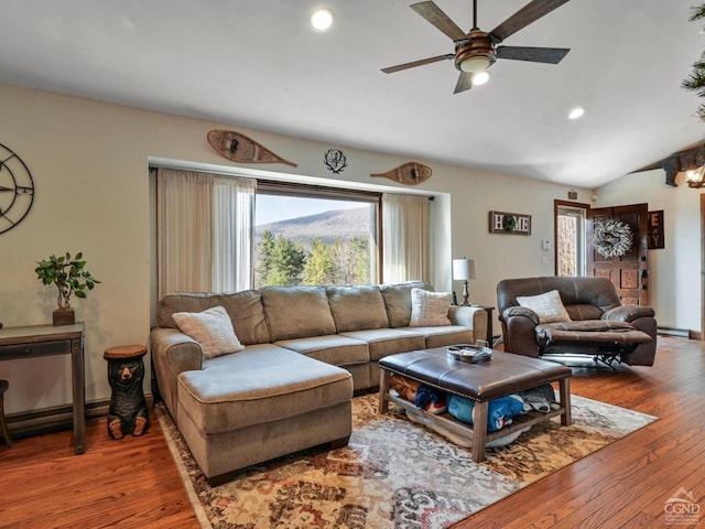 living room featuring hardwood / wood-style flooring, ceiling fan, a baseboard radiator, and vaulted ceiling