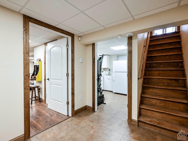 hallway with a paneled ceiling and light hardwood / wood-style flooring