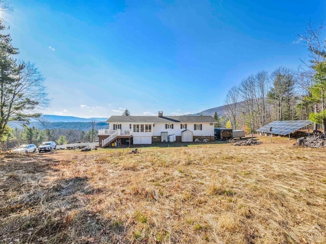 rear view of house with a deck with mountain view