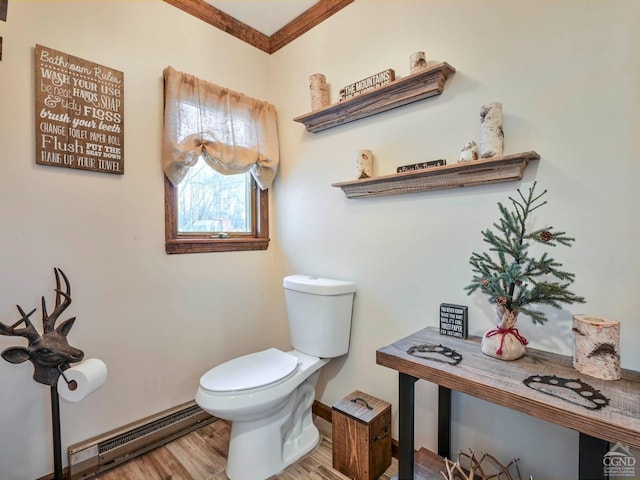 bathroom featuring a baseboard radiator, toilet, hardwood / wood-style flooring, and crown molding