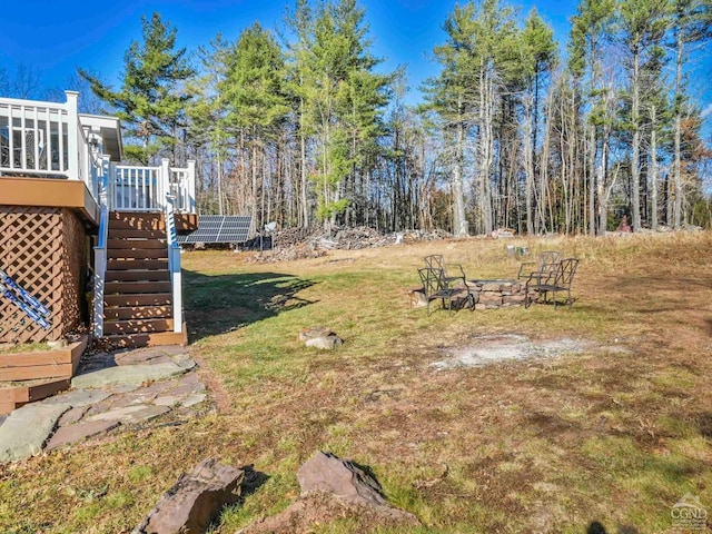 view of yard featuring an outdoor fire pit and a wooden deck