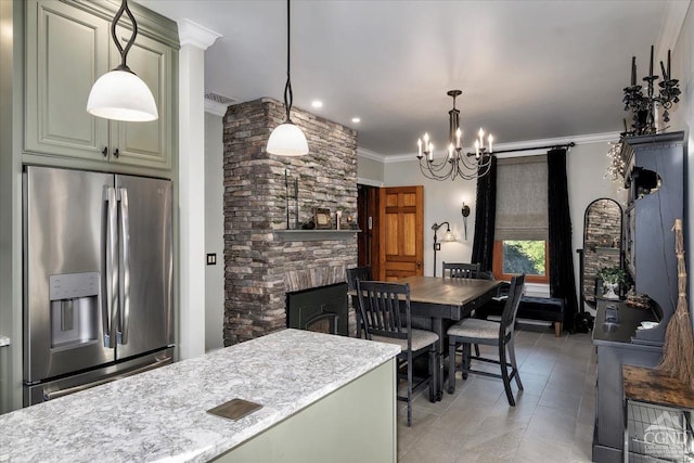 kitchen featuring hanging light fixtures, stainless steel fridge with ice dispenser, a chandelier, a fireplace, and ornamental molding